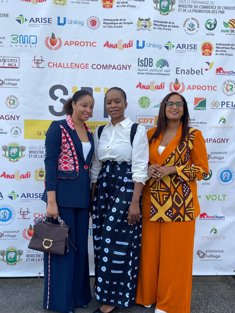 Mariame Diakité et deux participantes devant le mur des partenaires de la journée